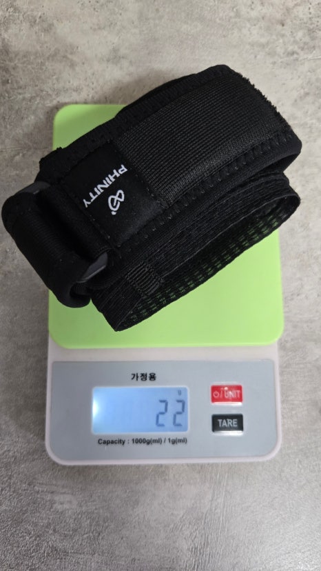 주방 저울 위에 올린 팔꿈치보호대 — 22g 표시