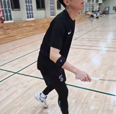 체육관에서 팔꿈치보호대를 착용하고 리시브 자세를 잡은 배드민턴 동호인